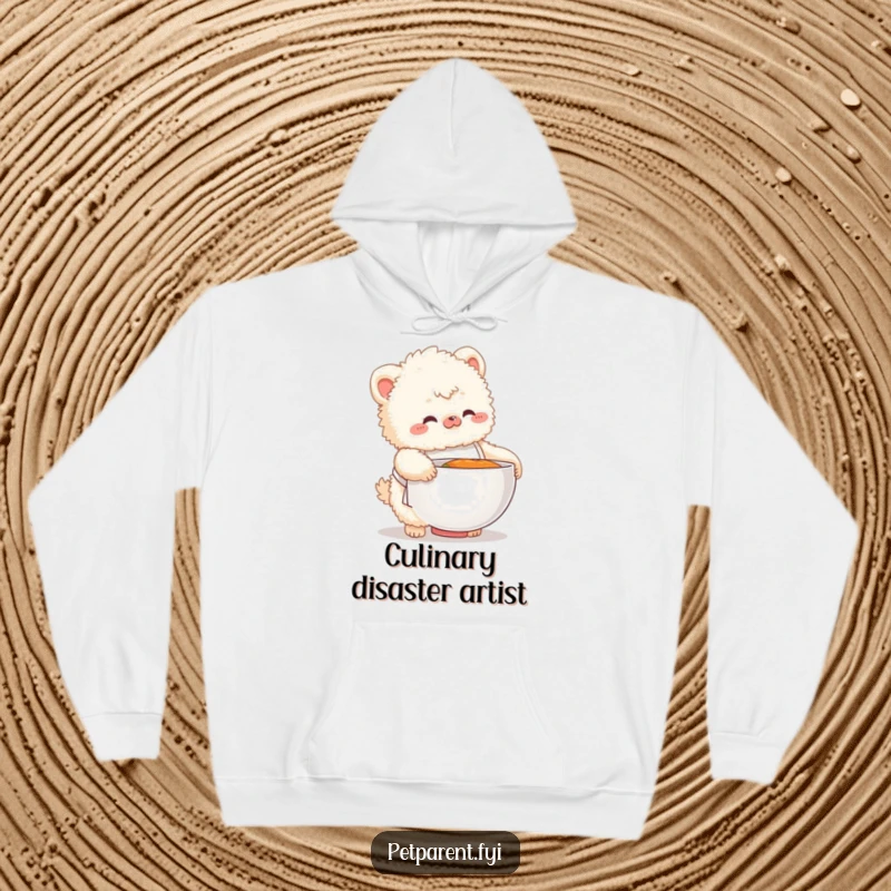 Funny hoodie featuring a fluffy creature in a small apron fumbling with a large food bowl, a humorous kitchen scene.