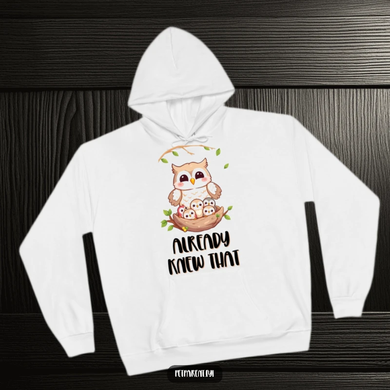Funny owl hoodie showing a motherly owl gazing lovingly at her owlets nestled safely in their home, radiating warmth and humor.